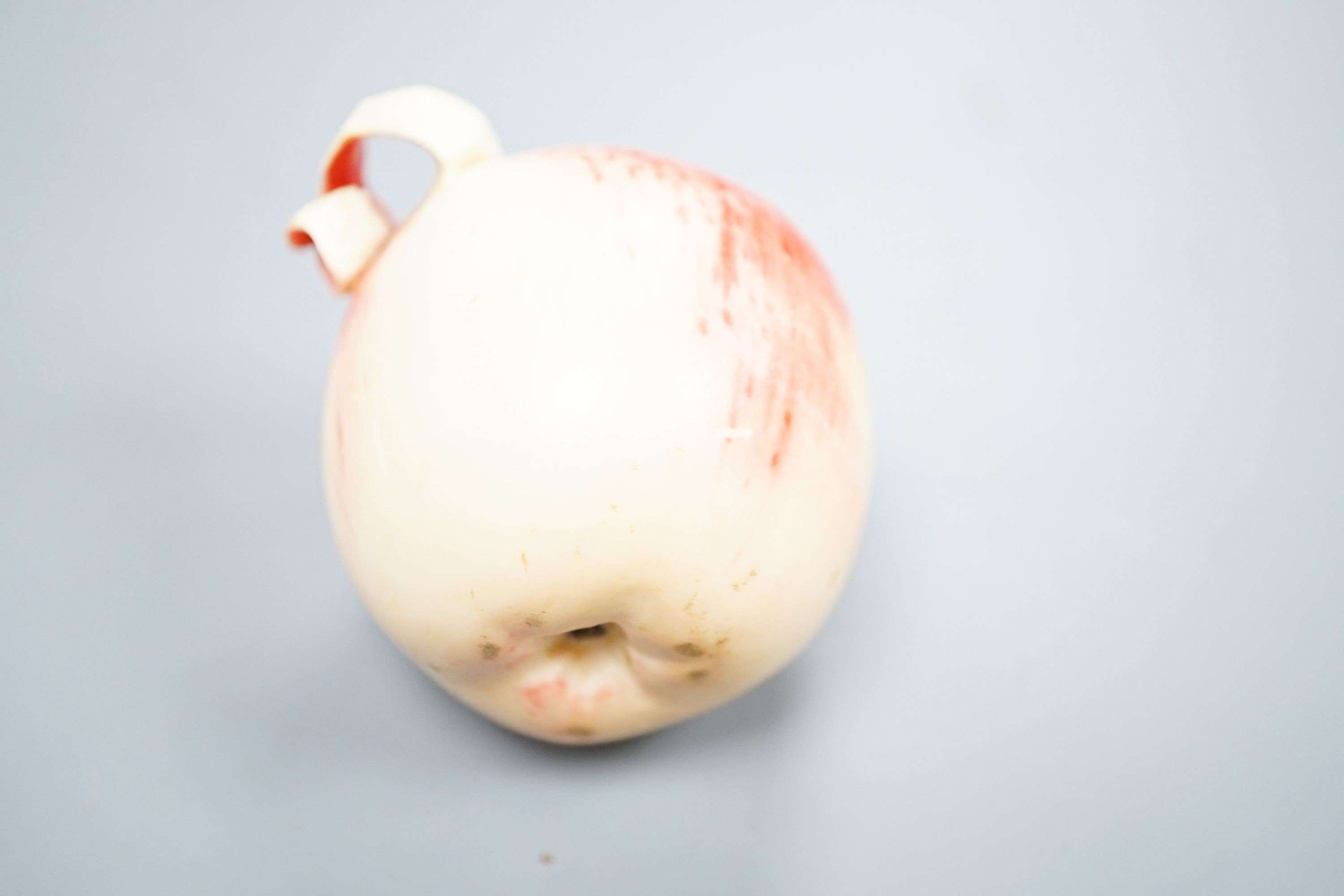 A Japanese carved ivory model of a partially peeled apple, c.1900, 5cm